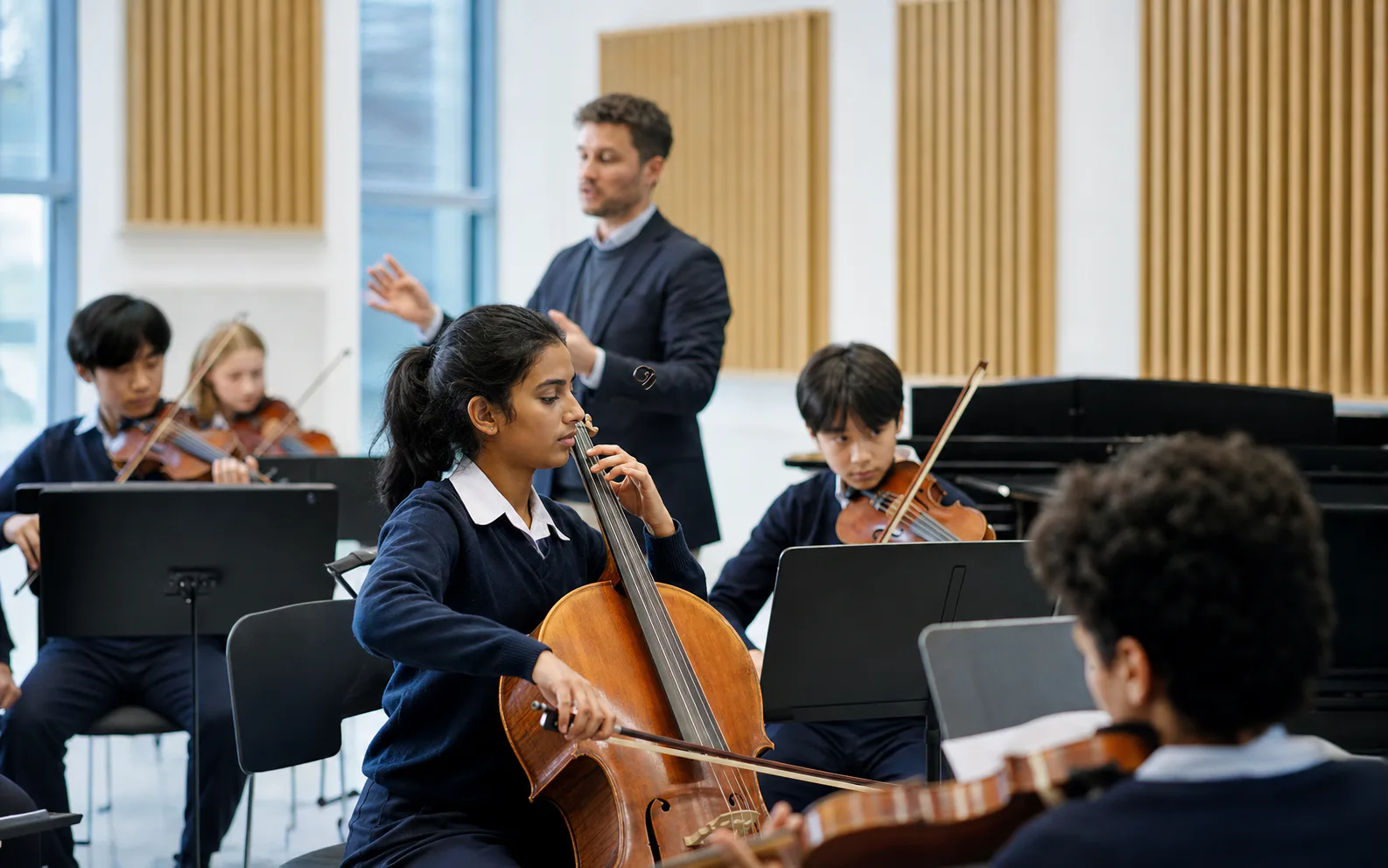 A diverse student chamber ensemble rehearsing with their teacher